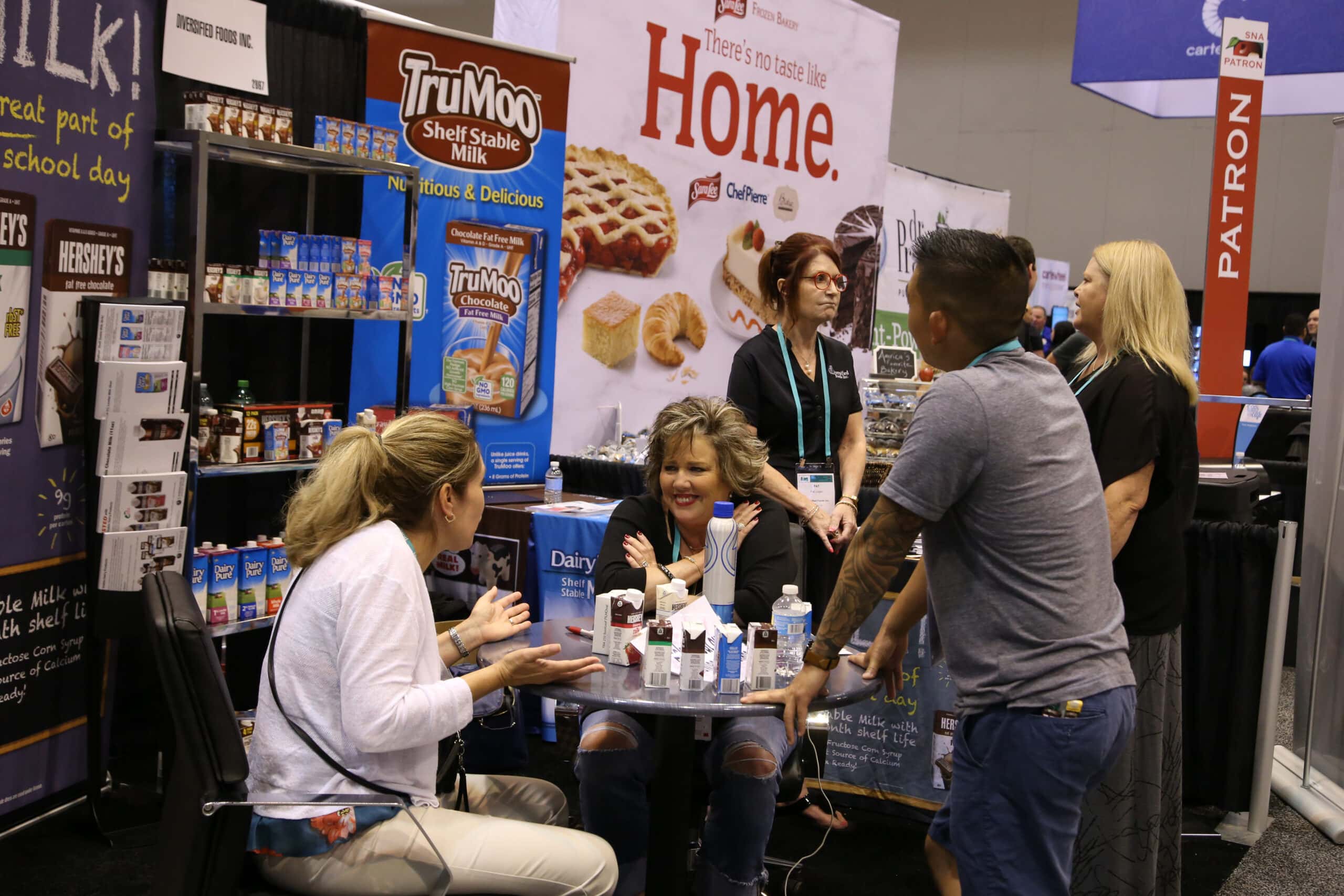 Two people at a table happily chatting in the Exhibit Hall